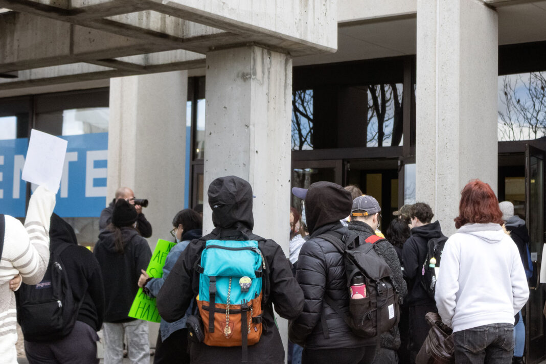 Landscape photo of a crowd of SLCC protesters gather after an altercation