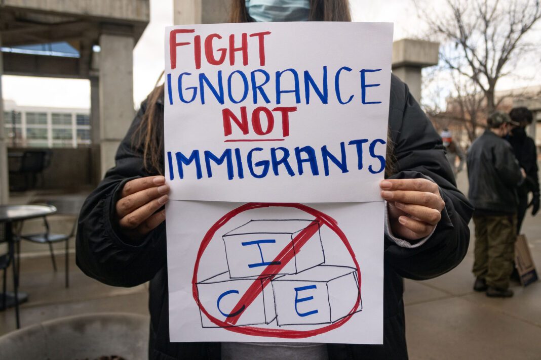 Landscape photo of an SLCC protester with a hand drawn sign