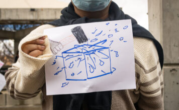 ‘DHS out of SLCC’: Students protest CBP recruitment on campus Landscape photo of SLCC protester with their hand made sign before interview. Face is cropped out.