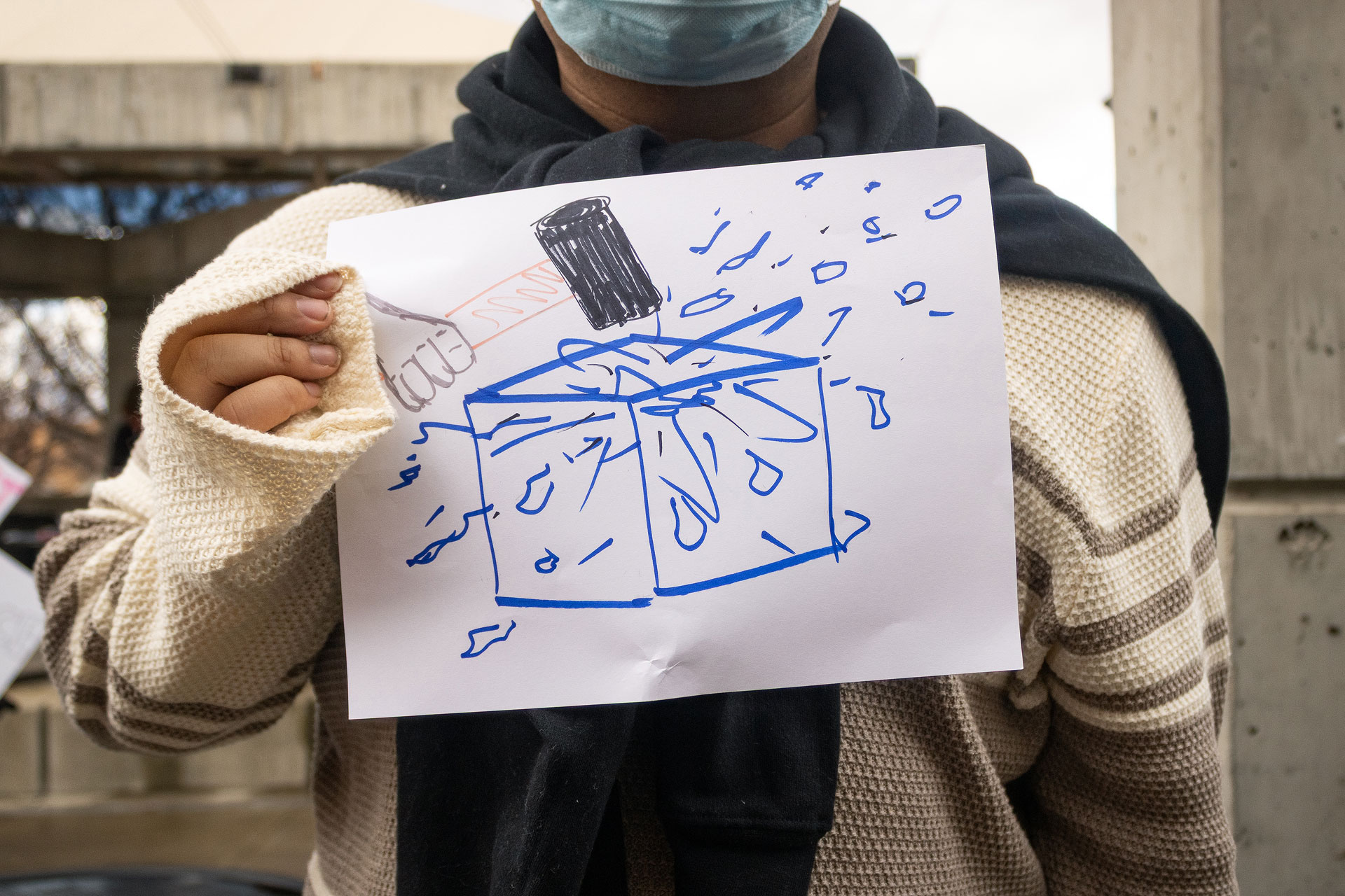 Landscape photo of SLCC protester with their hand made sign before interview. Face is cropped out.