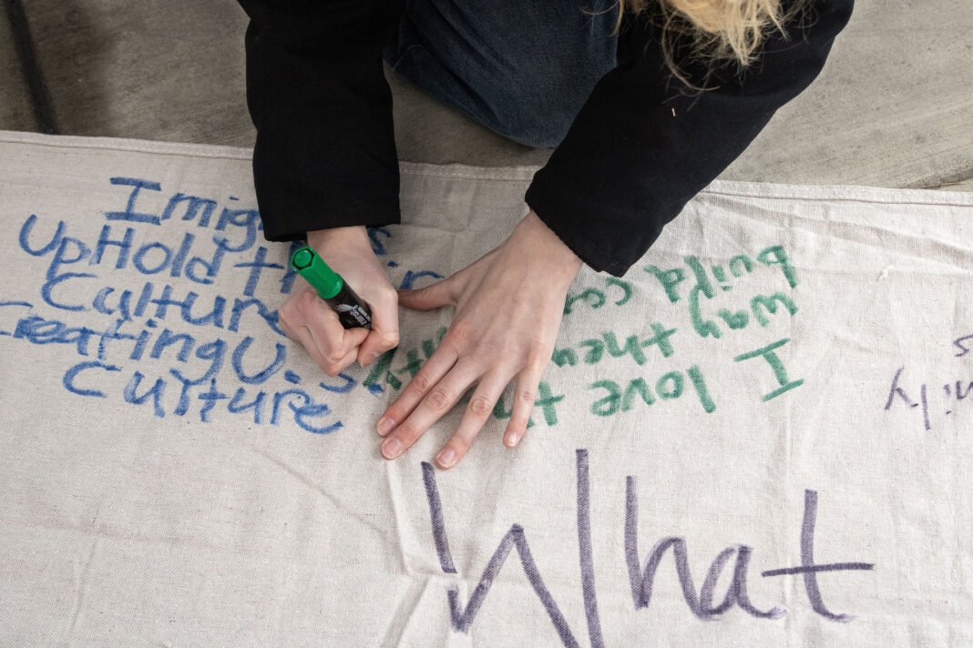 Landscape photo of a protester writing on a banner