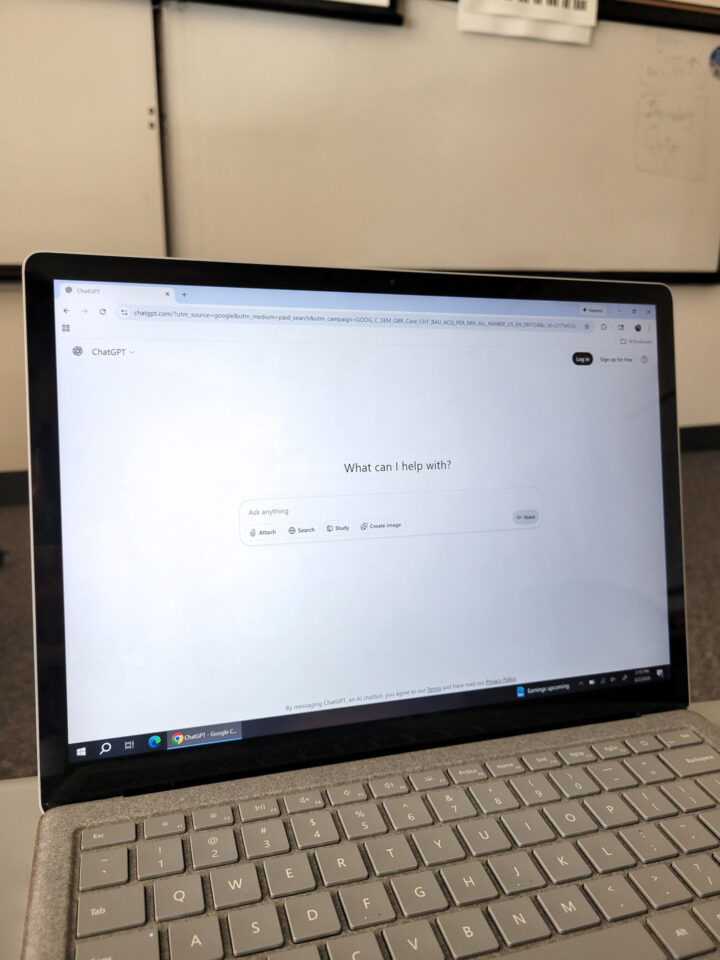 Laptop sitting on a classroom table displaying ChatGPT homepage