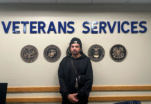 How SLCC helps military veterans navigate college Jaylen standing in front of a wall adorned with military seals and lettering that reads "veterans services"