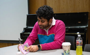 Forum speaker Alok Vaid-Menon uses humor to discuss gender, politics and self-validation Alok writing a message inside a book
