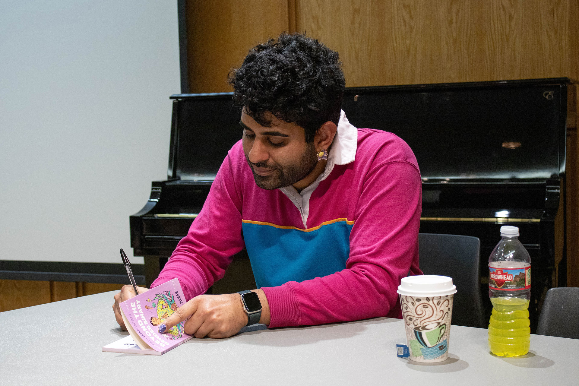Alok writing a message inside a book