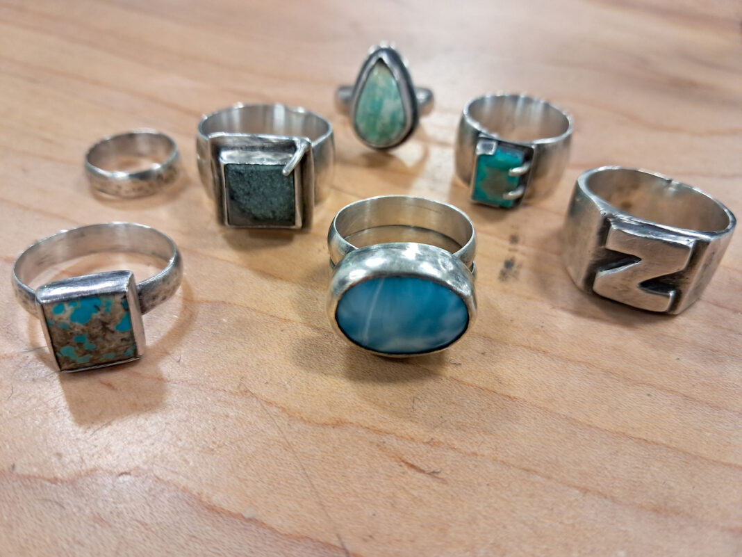 Seven rings of various designs sitting on a table