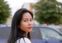 SLCC international student navigates studying in the U.S. Chan Phall wearing a backpack and holding the handles of a bicycle