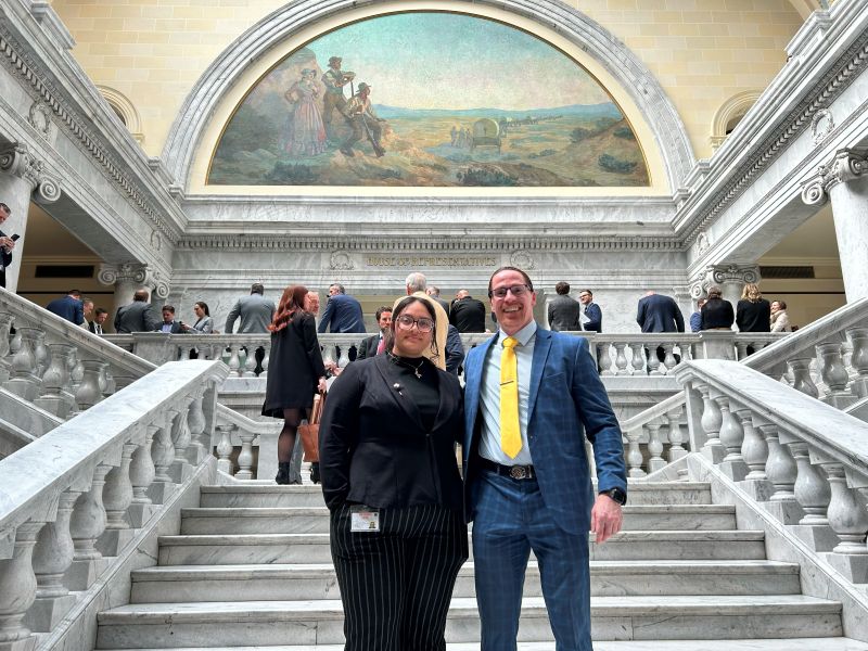 Ash Orduna and President Peterson standing on marble staircase