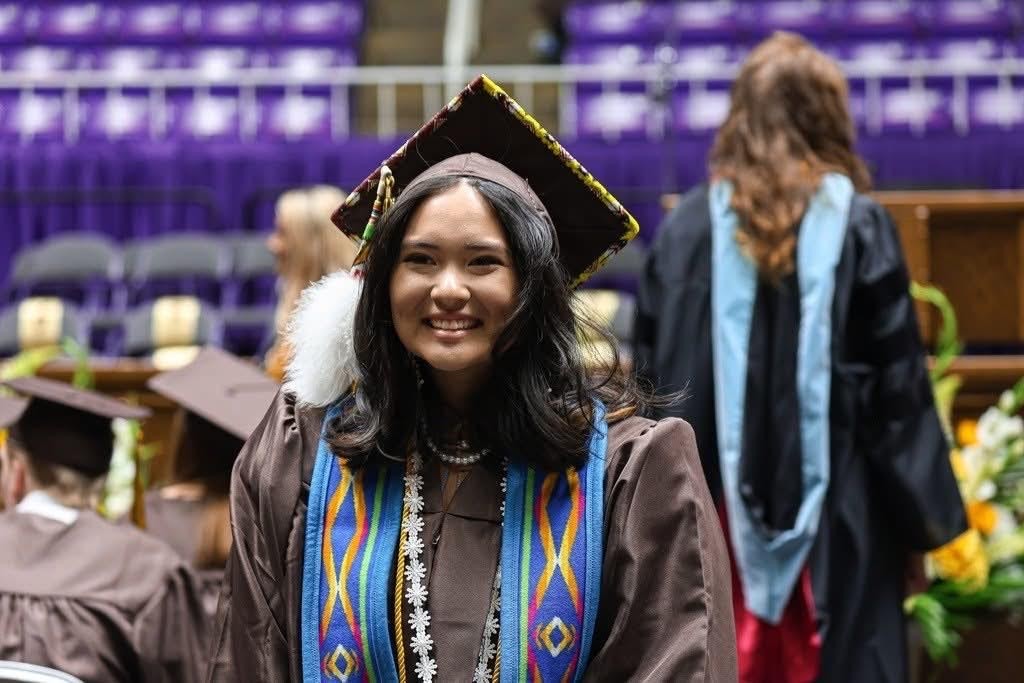 Eya walking in cap and gown for graduation