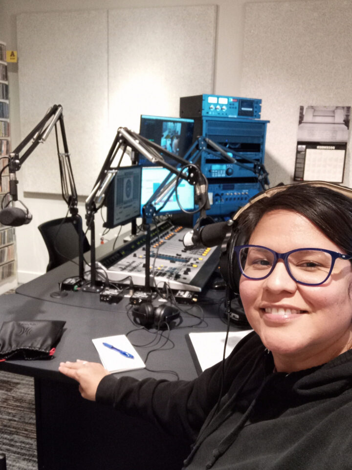 Valene sitting at a desk inside a radio station