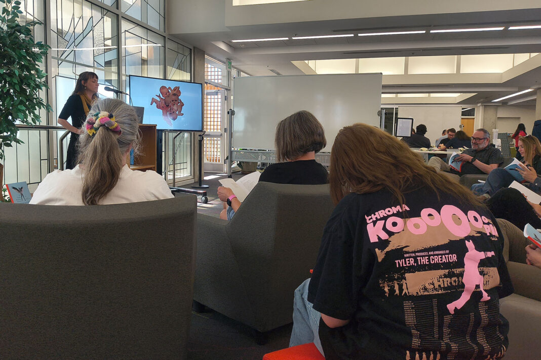 Kathryn Cowles reading poetry while standing in front of an audience