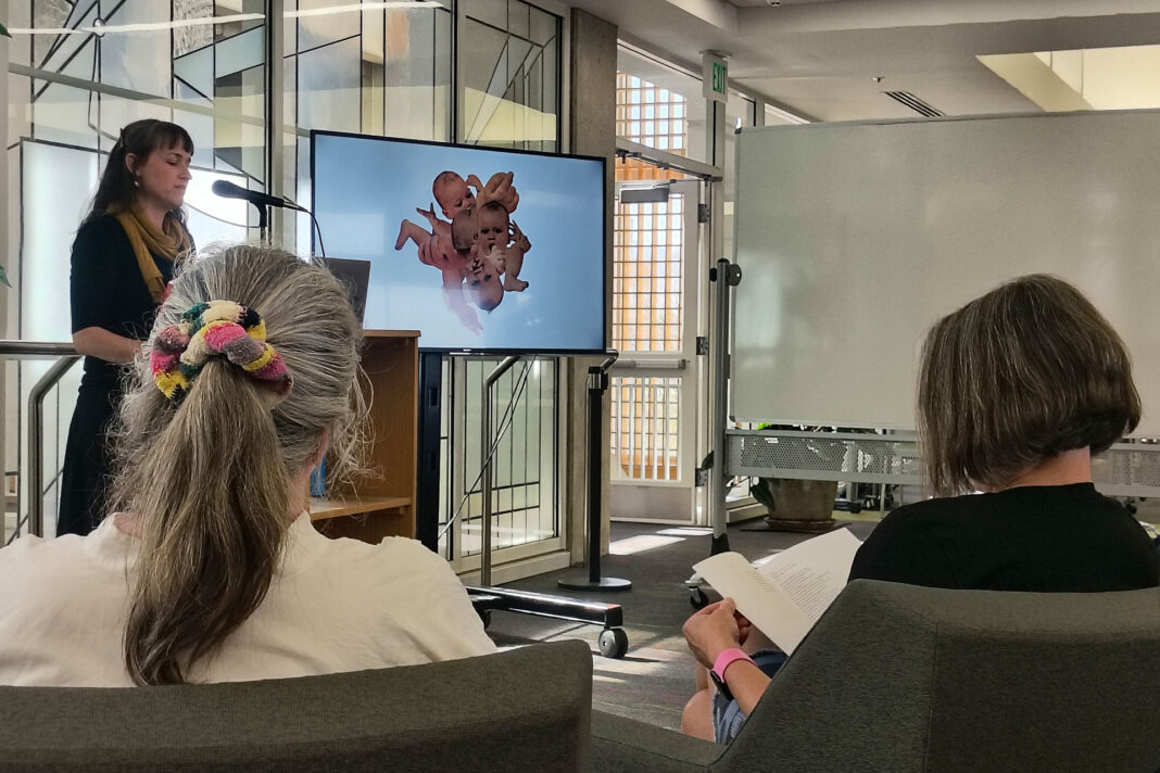 Kathryn Cowles reading poetry while her collage is displayed on a screen