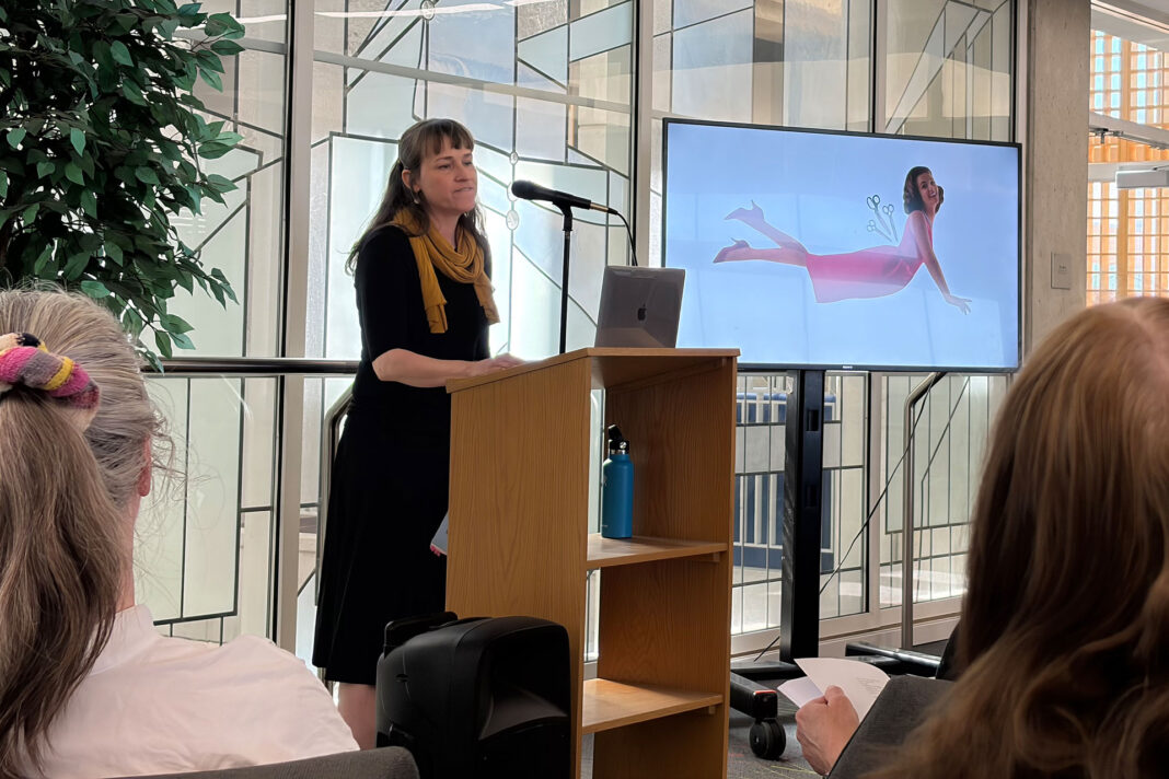 Kathryn Cowles reading poetry while her collage is displayed on a screen