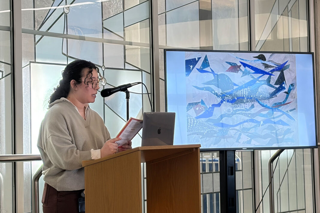 Erica Gudino reading a poem while standing behind a lectern