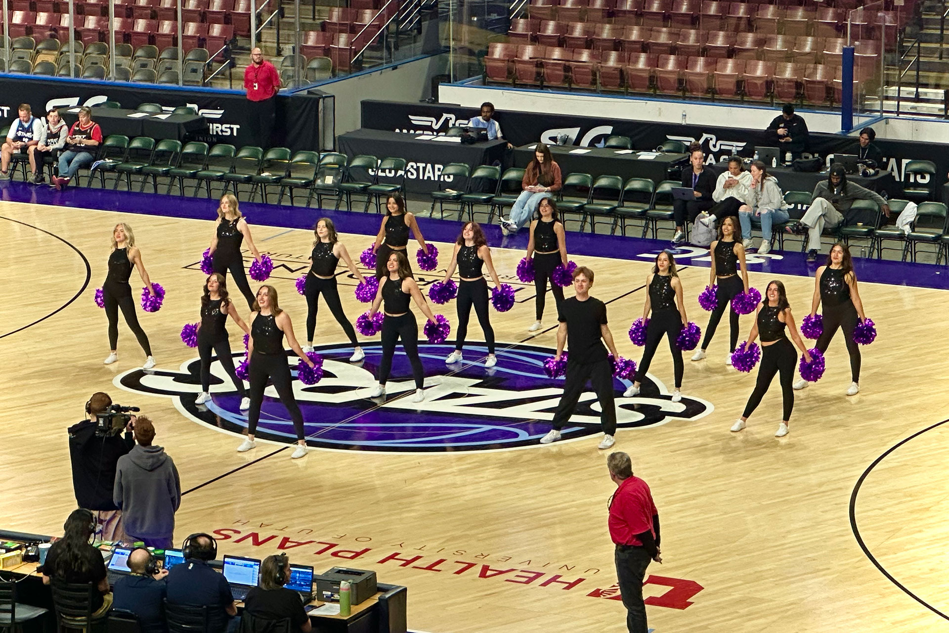 Group of dancers performing on center of basketball court