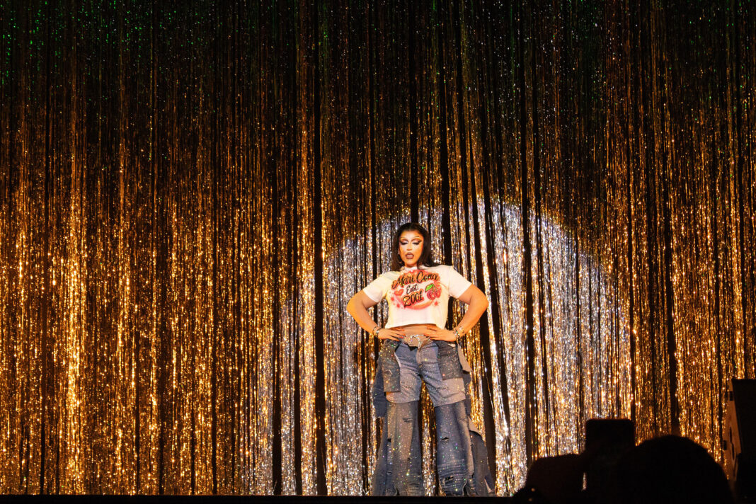 Mari Cona standing with hands on hips under a spotlight