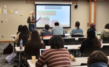 Workshop series teaches financial literacy Amanda explaining types of credit use during a presentation to students