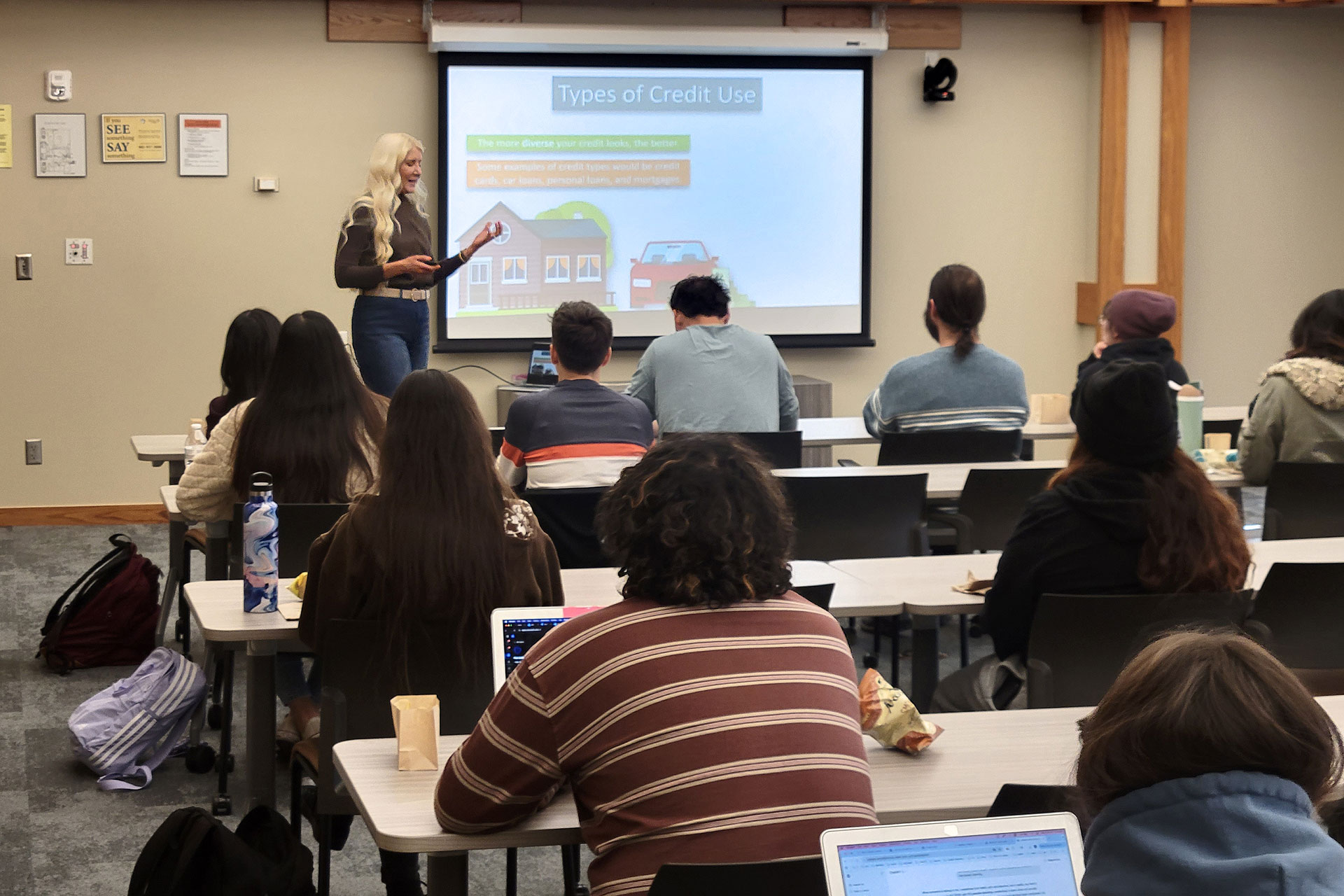 Amanda explaining types of credit use during a presentation to students