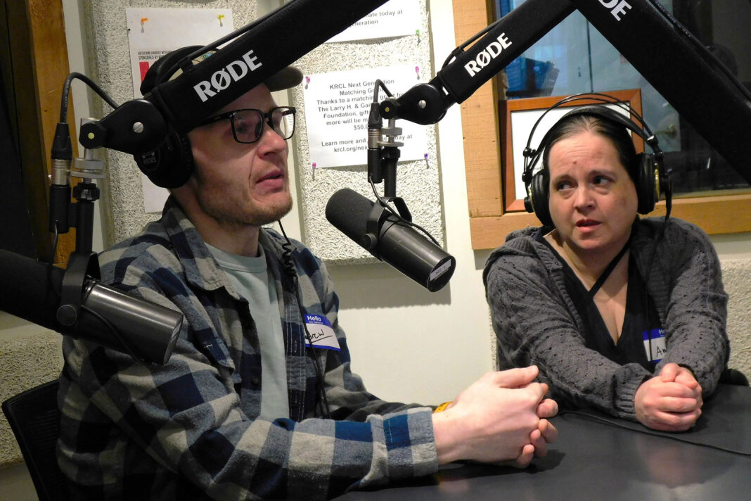 Two people speaking into microphones during a radio show