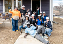 Alternative Break: SLCC students spend spring break on service projects Students smiling and posing for a picture in front of a house under construction