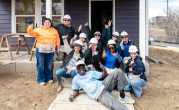Alternative Break: SLCC students spend spring break on service projects Students smiling and posing for a picture in front of a house under construction