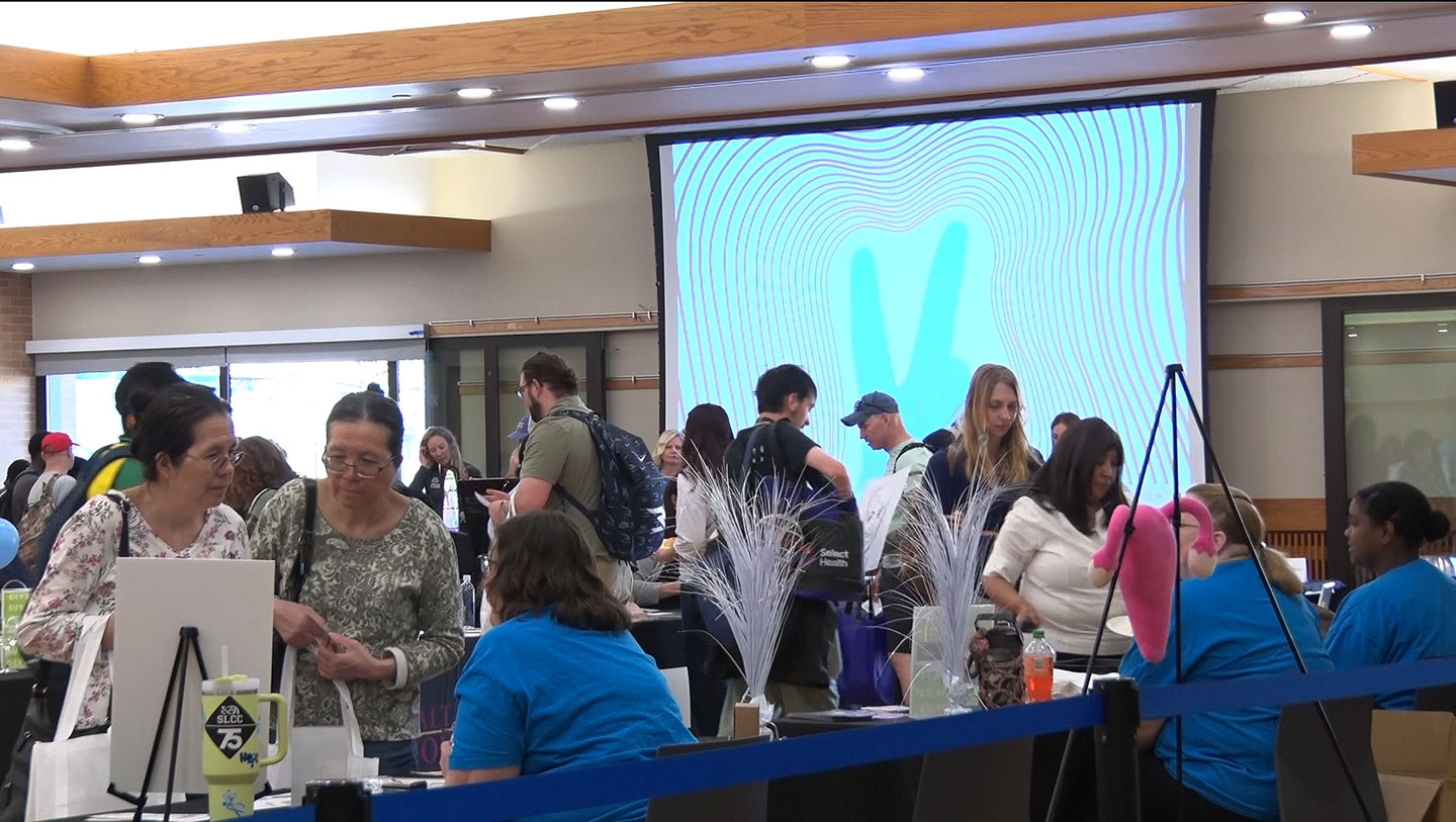 People gathering information at tables inside the Student Center
