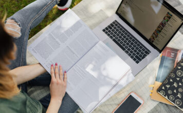Letter to the editor: How occupational therapy principles can benefit college students: You cannot pour from an empty glass Woman reading an open book outside under shade with laptop and phone