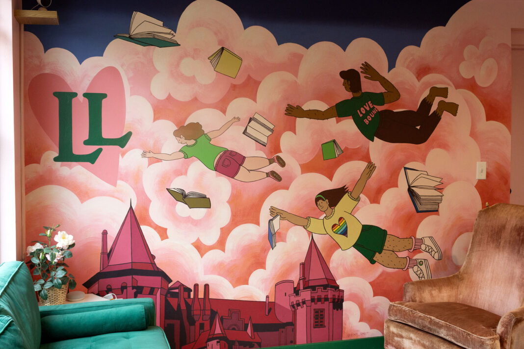 Mural of people and books floating in pink clouds