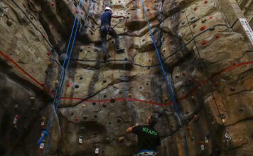 How SLCC is helping to uplift Utah’s climbing legacy Climber ascending a rock wall with an instructor standing below