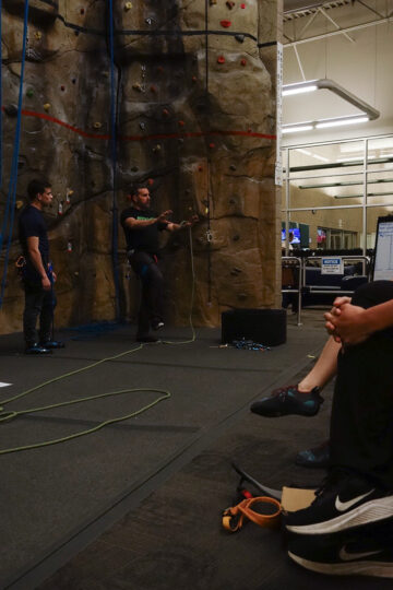 Instructors explaining a technique inside a climbing studio