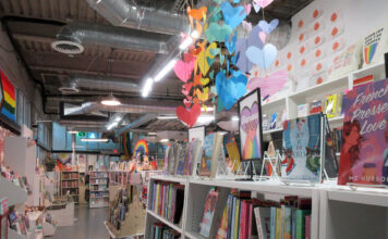 Queer book recommendations for Pride Month and beyond Rainbow-colored decorations hanging inside a bookstore