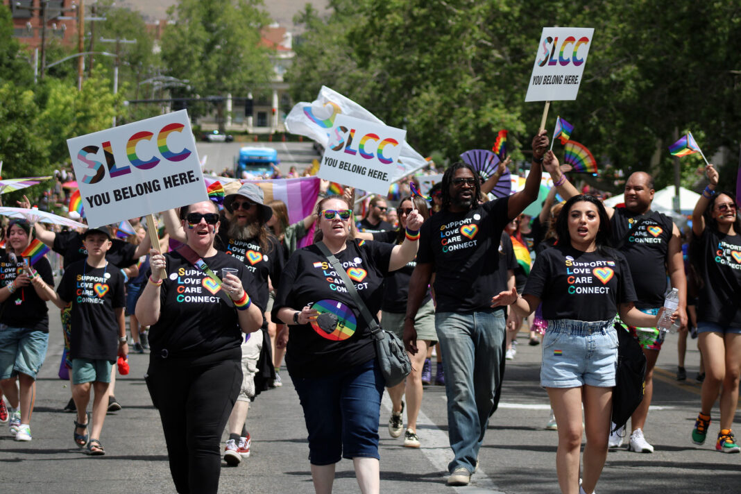 Pride parade participants walking down a city street