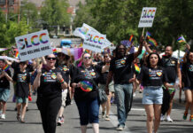 In photos: SLCC shows its true colors in the 2026 Utah Pride Parade Pride parade participants walking down a city street