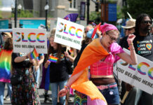 SLCC marks 12th year marching in Utah Pride Parade People holding SLCC signs behind a dancing paradegoer