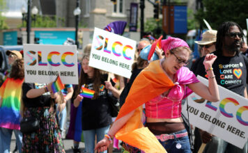 SLCC marks 12th year marching in Utah Pride Parade People holding SLCC signs behind a dancing paradegoer
