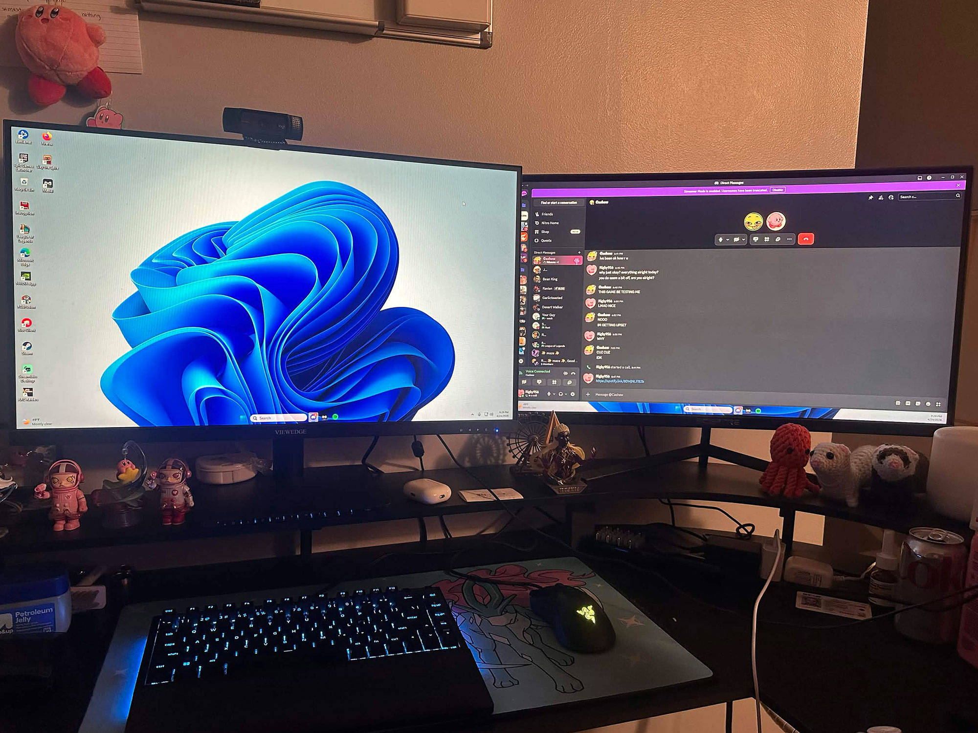 Two monitors, keyboard and mouse illuminated on a desk