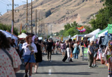 In photos: Continuing SLC Pride’s ‘by community, for community’ Festivalgoers walk past vendor booths on a city street