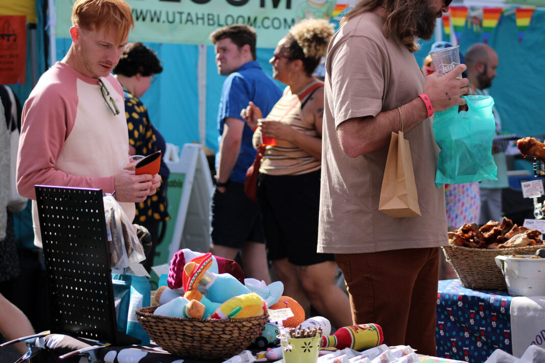 Festivalgoers viewing merchandise for sale on tables