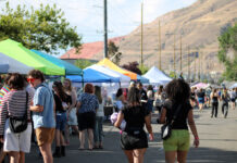 SLC Pride creates free, inclusive alternative to Utah Pride Festivalgoers socializing and walking past vendor booths on a city street