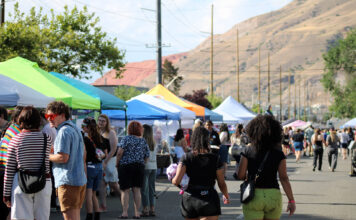 SLC Pride creates free, inclusive alternative to Utah Pride Festivalgoers socializing and walking past vendor booths on a city street