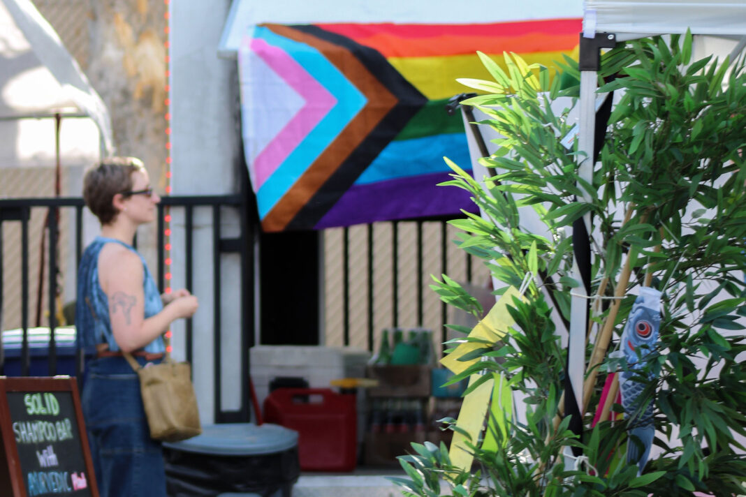 Festivalgoer surrounded by decorations and a pride flag