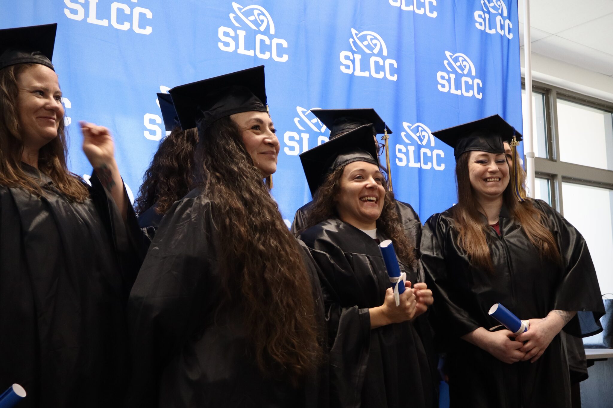 SLCC graduates wearing black caps and gowns