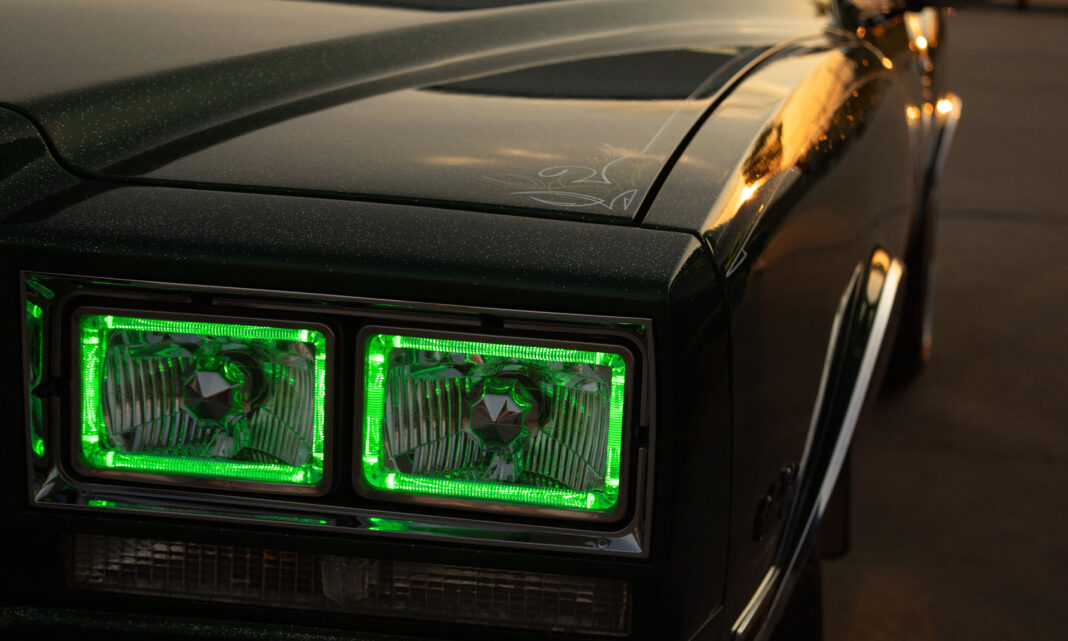Dark-colored car with custom accents being displayed in the early evening