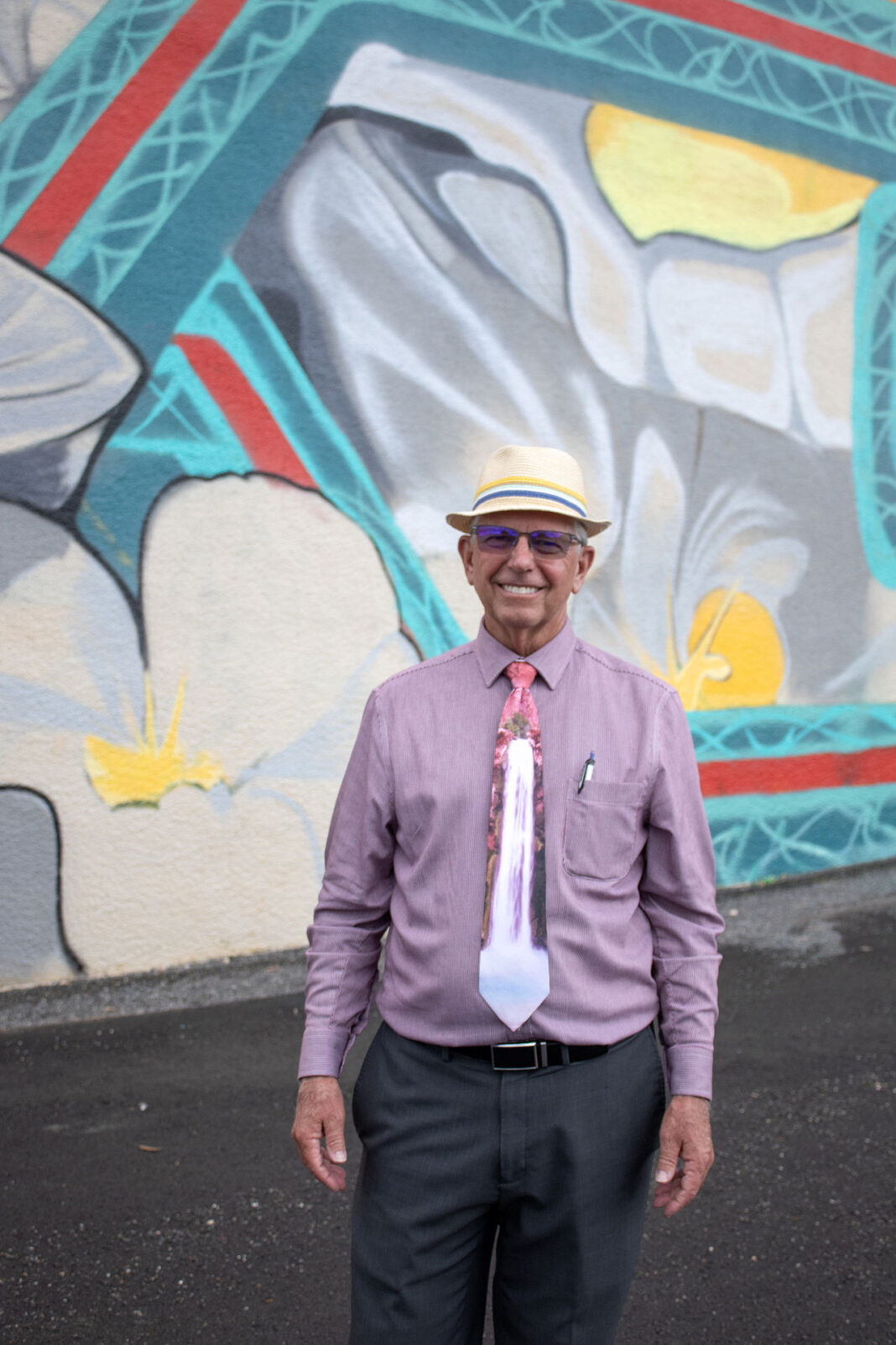 Dirk Burton smiling in front of a new mural in the city