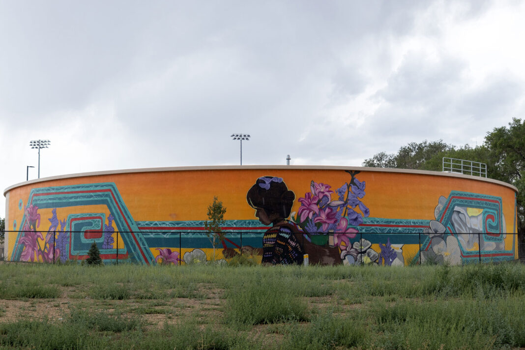 Water tank decorated with a painted mural of an Indigenous girl