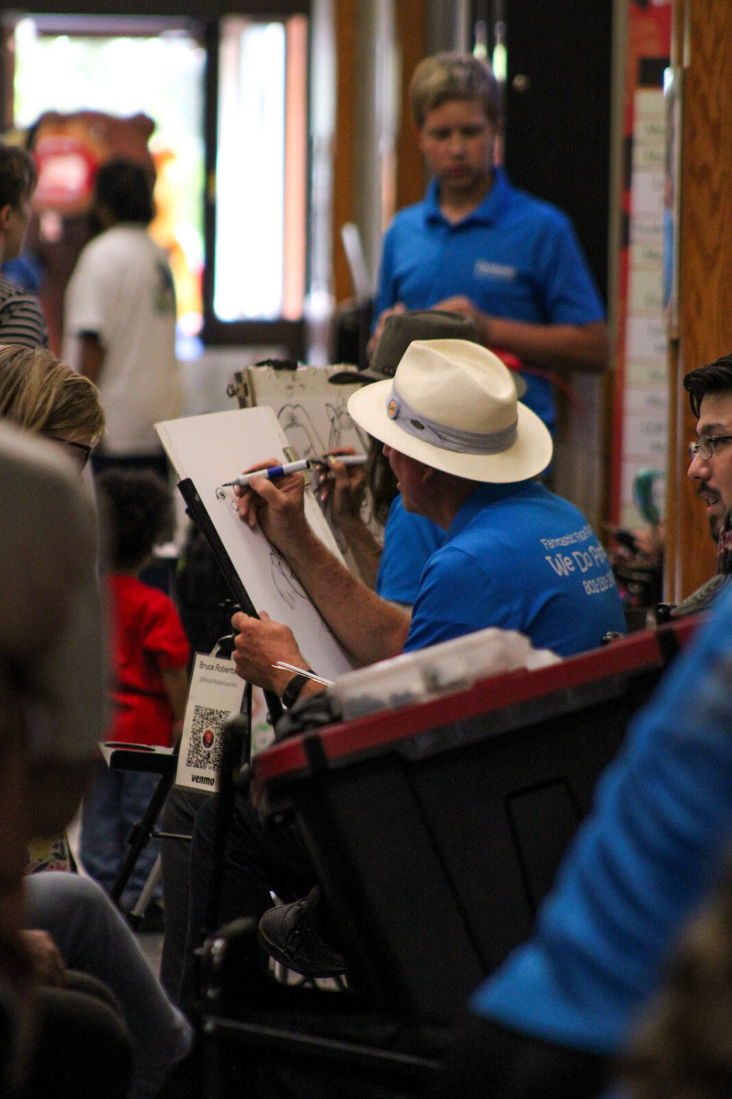 Artist drawing a sketch while surrounded by people