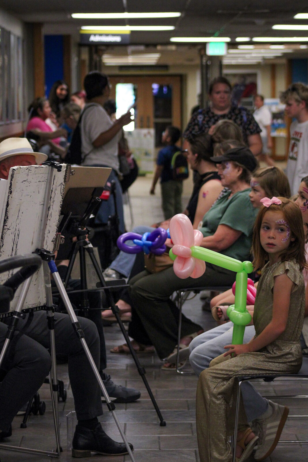 People sitting and getting their portraits drawn by artists