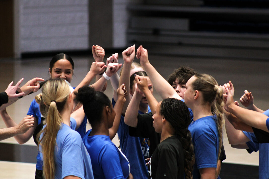 Basketball players huddling together with raised fists