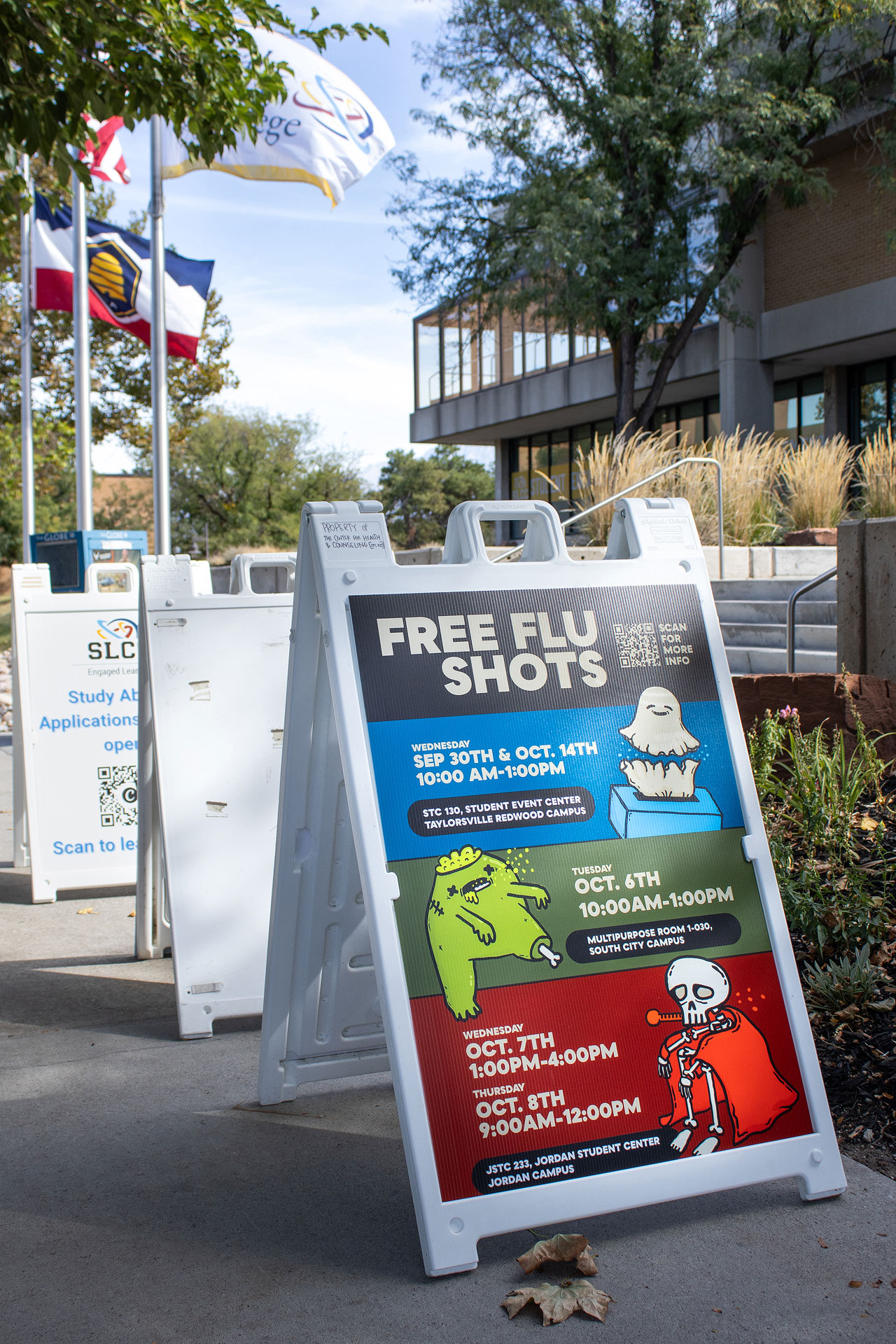 Folding sign displaying free flu shots poster with clinic schedule