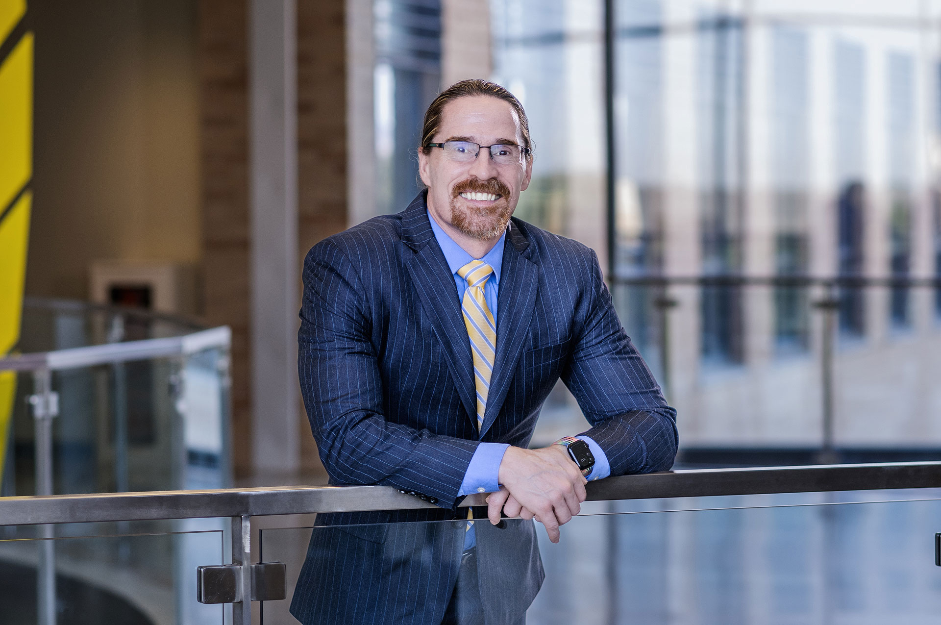 President Peterson leaning forward on a railing during a photo shoot